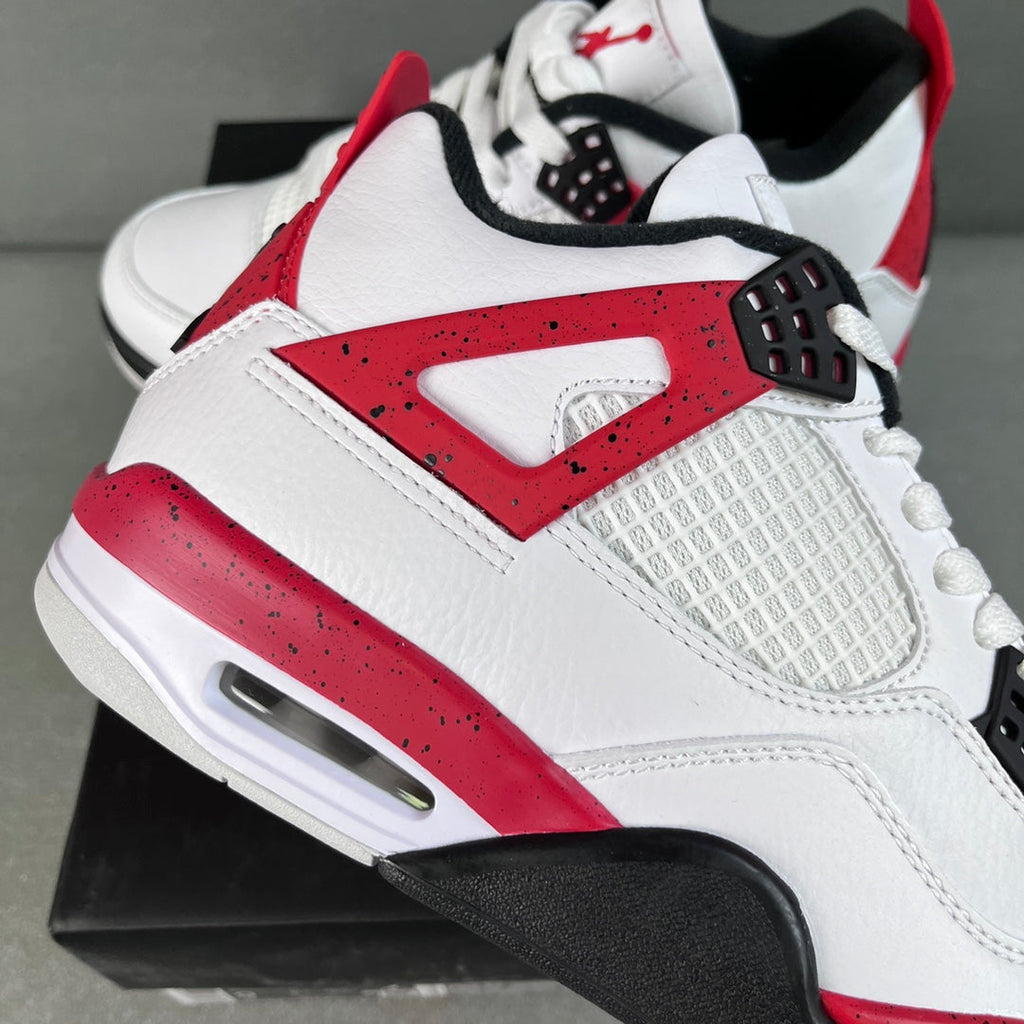 Air Jordan 4 sneaker side view, white upper with red lace panel and black sole
