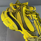 Balenciaga sneakers side view in yellow mesh with black stripe detailing, green laces