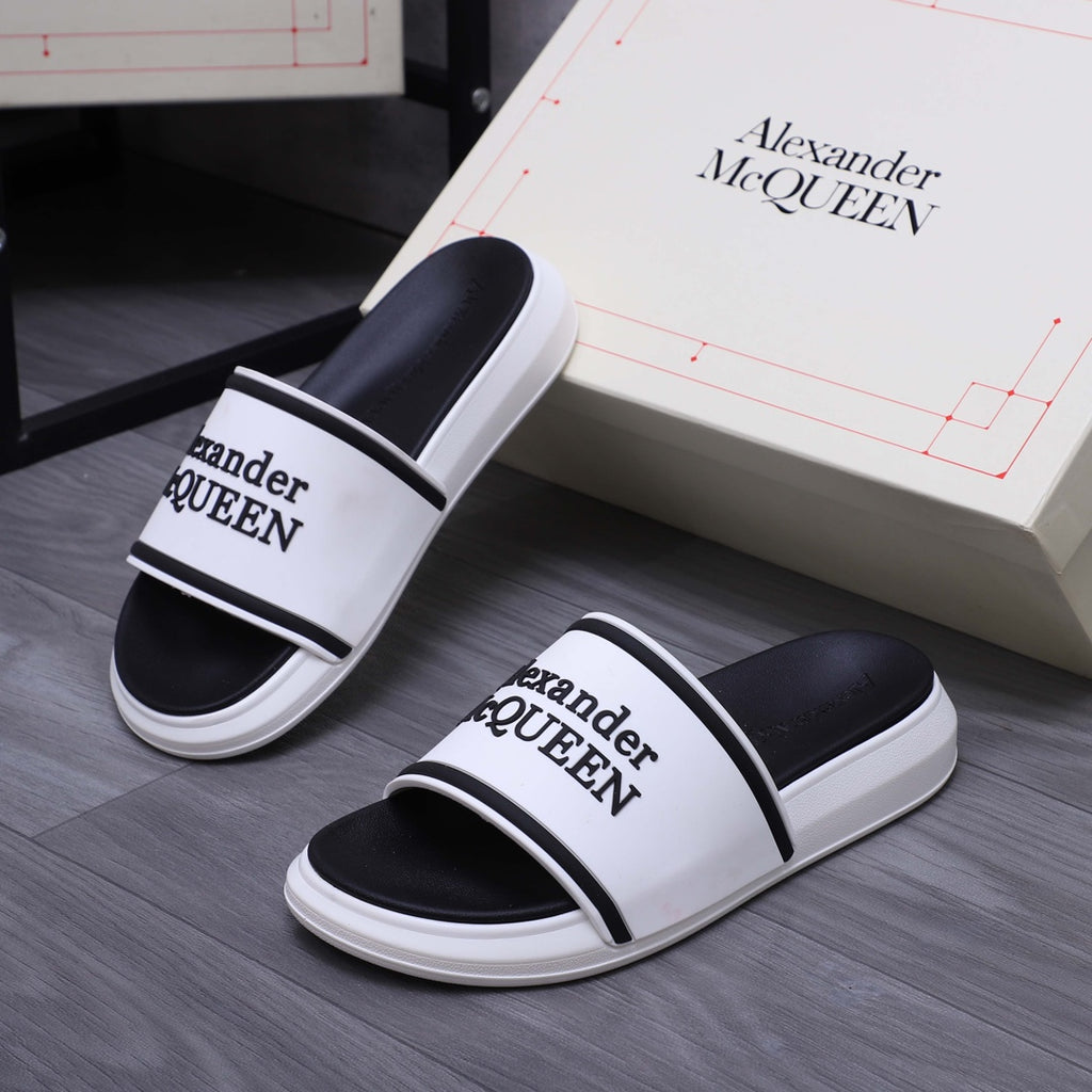Alexander McQUEEN slide sandals on floor, white footbed with black strap bands