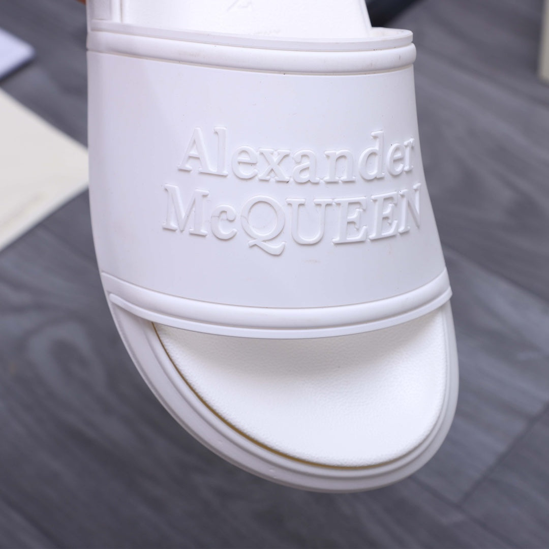 White slide sandal close-up: embossed logo on upper band