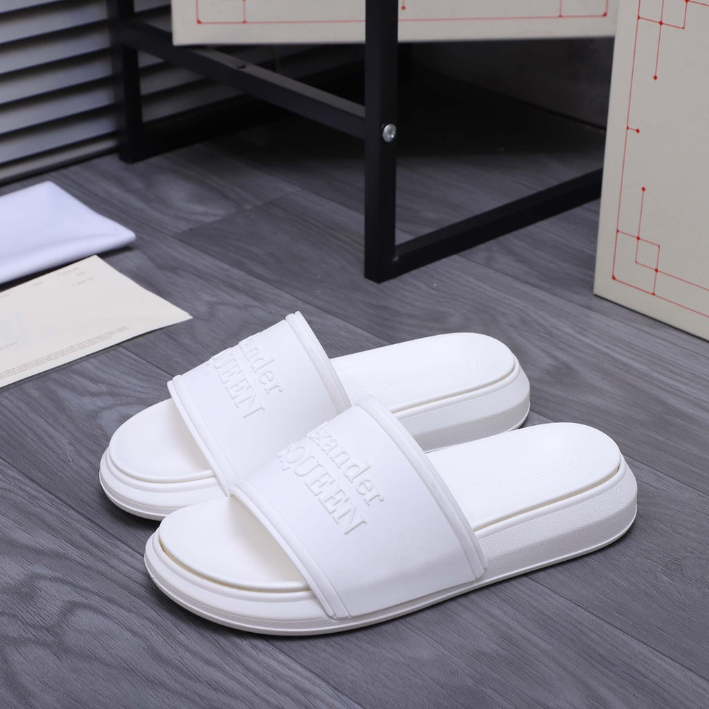 White slide sandals, front view, wide strap and embossed logo on footbed