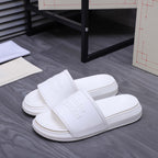 White slide sandals, front view, wide strap and embossed logo on footbed