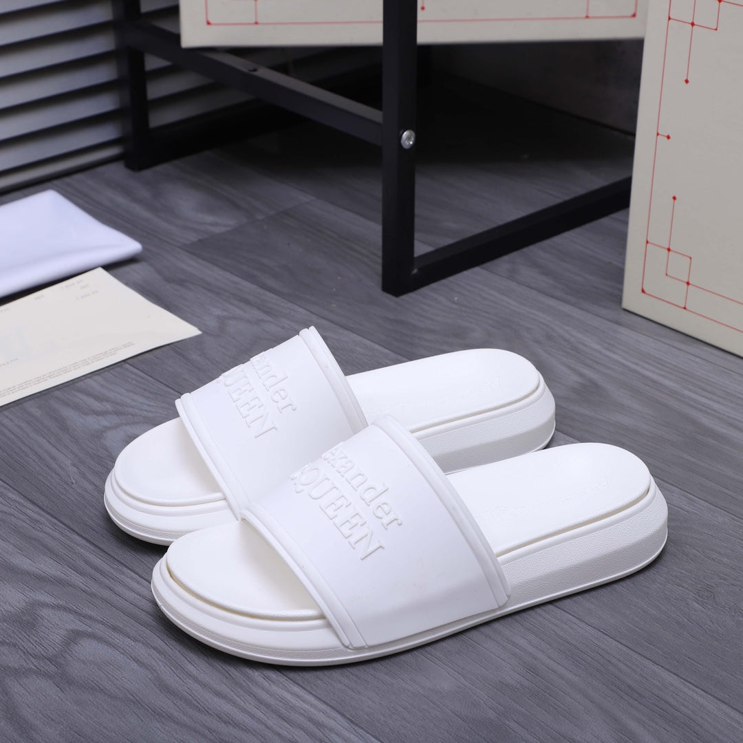 White slide sandals, front view, wide strap and embossed logo on footbed