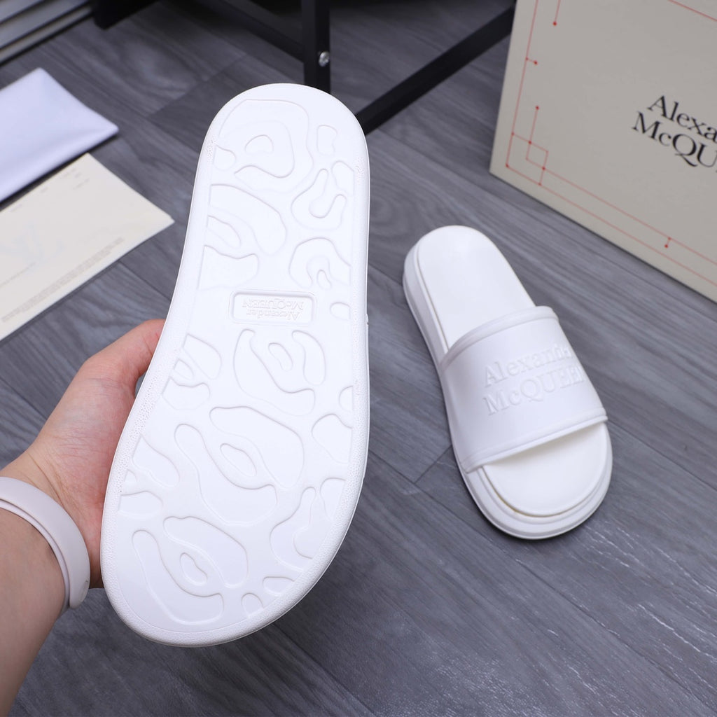 White slide sandal outsole view with textured tread pattern
