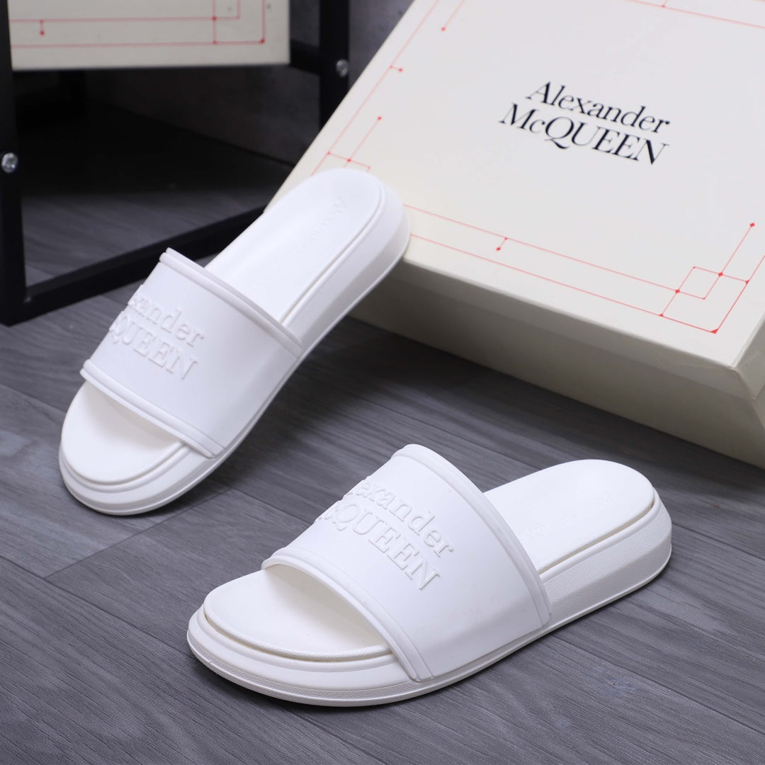 White slide sandals with wide strap and embossed logo on footbed