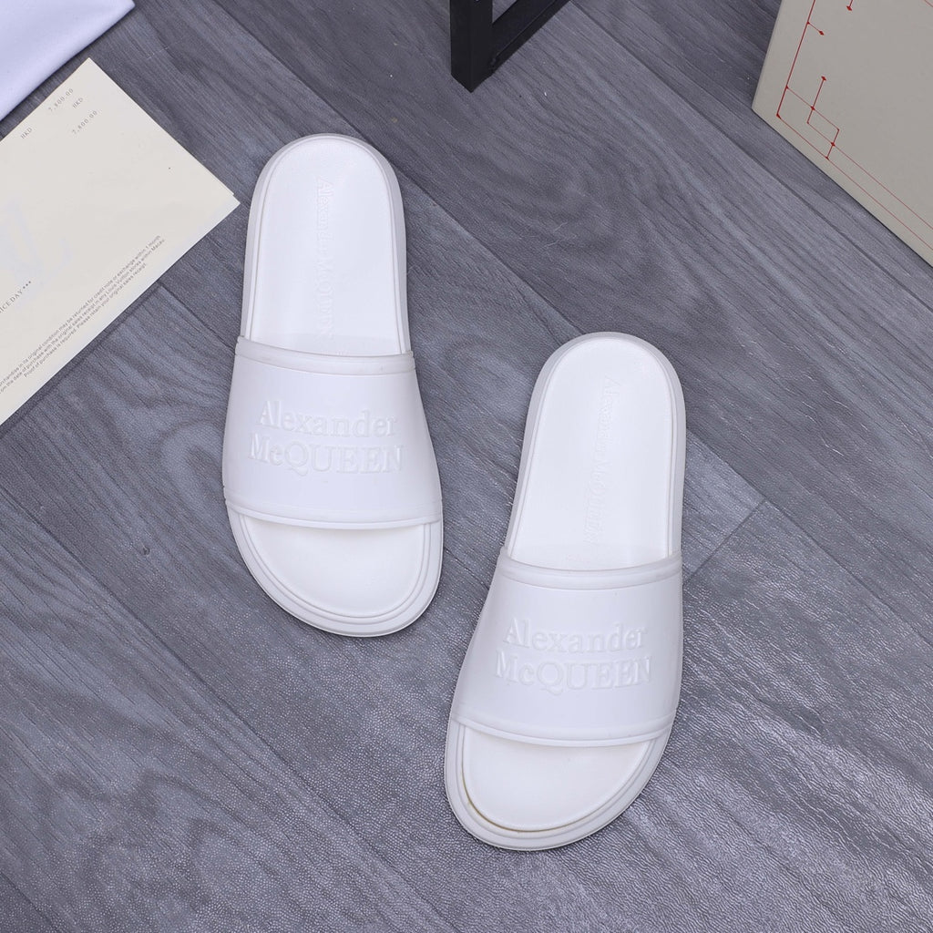 White slide sandals pair with wide strap and embossed logo on footbed