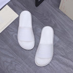 White slide sandals pair with wide strap and embossed logo on footbed