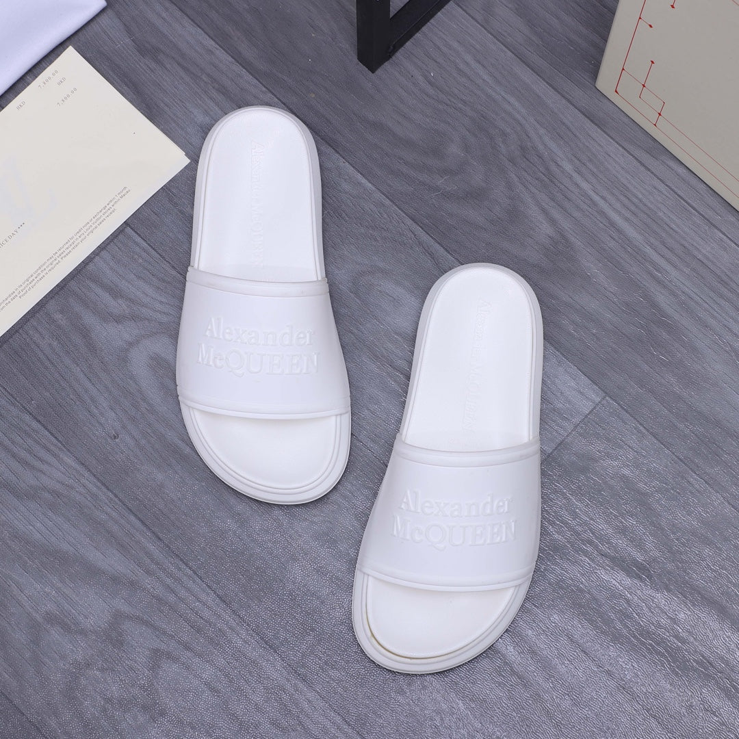 White slide sandals pair with wide strap and embossed logo on footbed