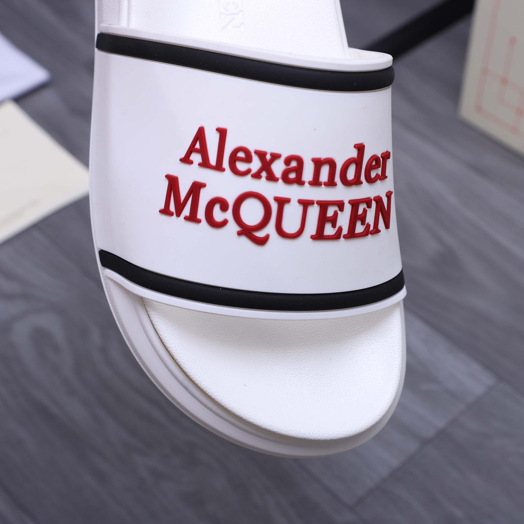 Close-up of white slide sandal strap with red Alexander McQUEEN logo and black trim