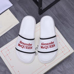 White slide sandals with black strap trim and red Alexander McQUEEN logo