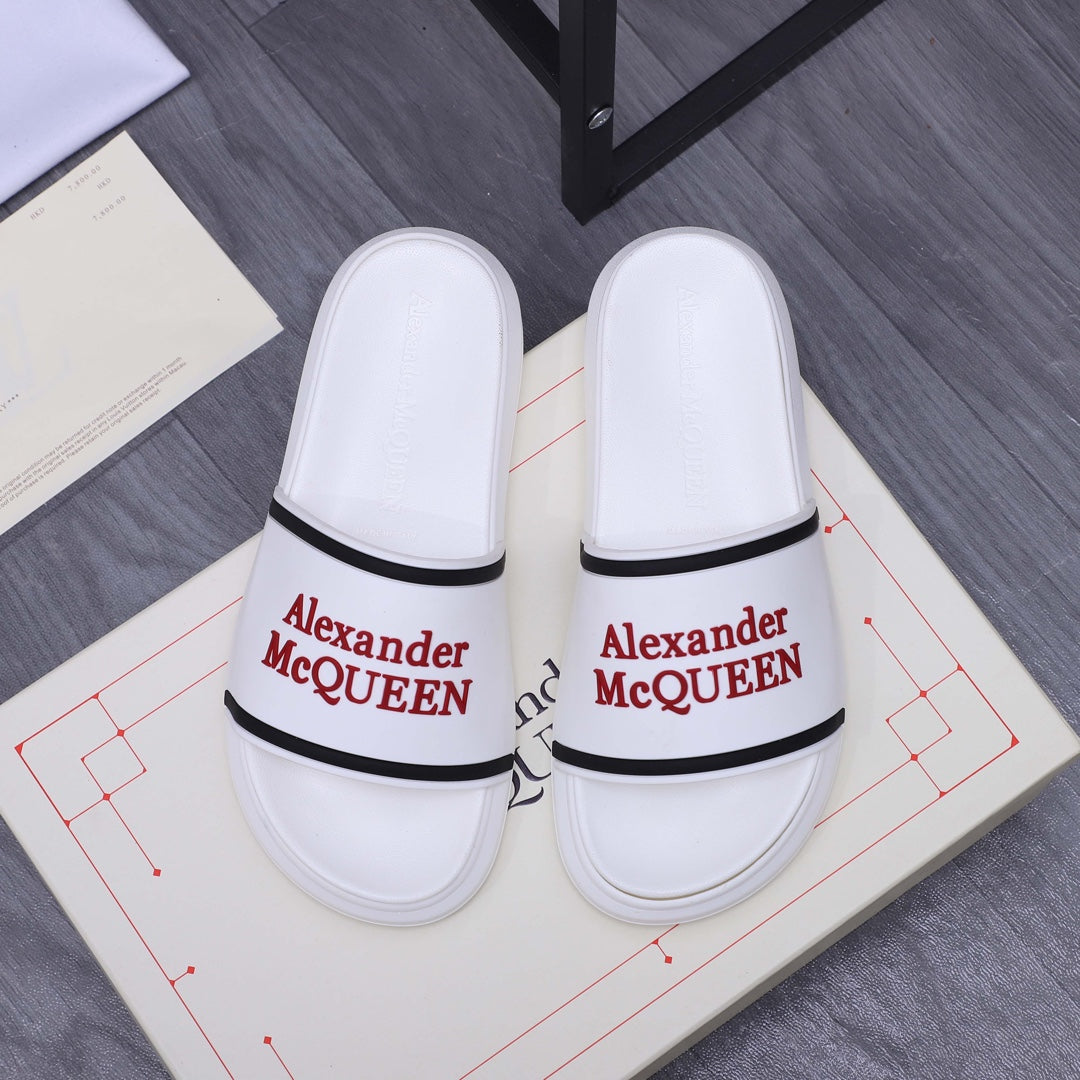 White slide sandals with black strap trim and red Alexander McQUEEN logo