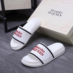 Pair of white slide sandals with black strap band and red Alexander McQUEEN logos