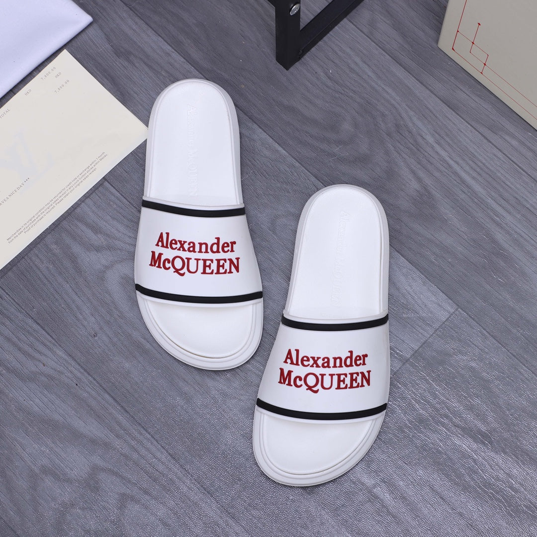 Two white slide sandals with black strap band and red Alexander McQUEEN branding