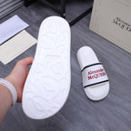 White slide sandal outsole with embossed design, shown beside matching slides