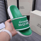 Green slide sandal in hand with Alexander McQUEEN logo on the wide strap