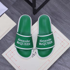 Green slide sandals with white trim and Alexander McQUEEN logo on the strap