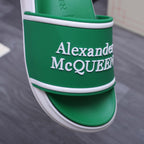 Green slide sandal strap detail with Alexander McQUEEN logo and white trim