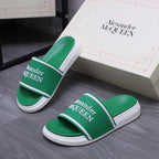 Green slide sandals with white soles and Alexander McQUEEN logo on the strap