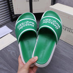 Green slide sandals showing footbed and Alexander McQUEEN logo on the strap