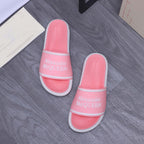 Pair of pink slide sandals with wide strap and Alexander McQueen logo, white trim