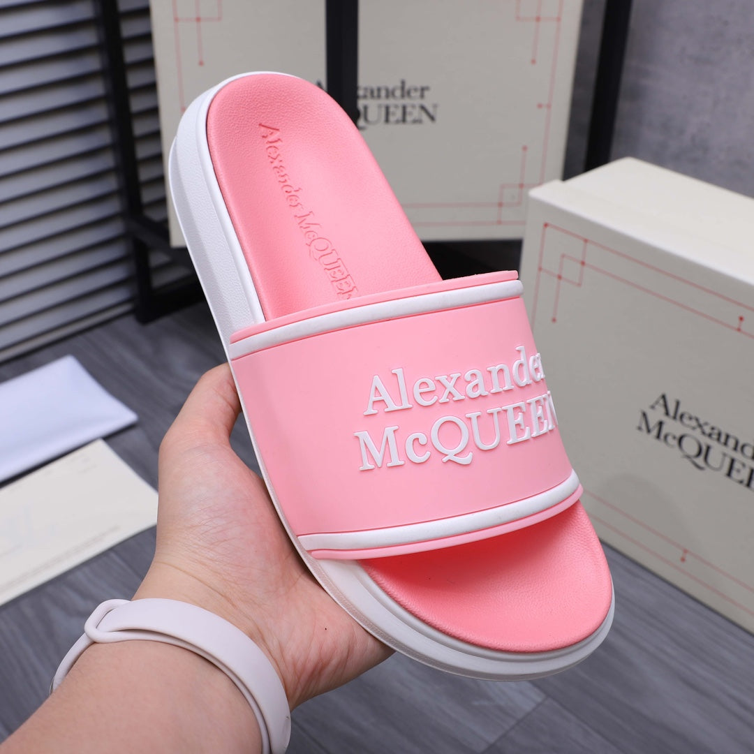 Pink slide sandal shown from side with wide strap and Alexander McQueen logo