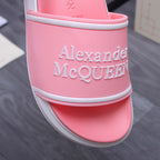 Pink slide sandal close-up of side strap with Alexander McQueen name, white trim