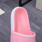 Pink slide sandal footbed with embossed Alexander McQueen text, white sidewall