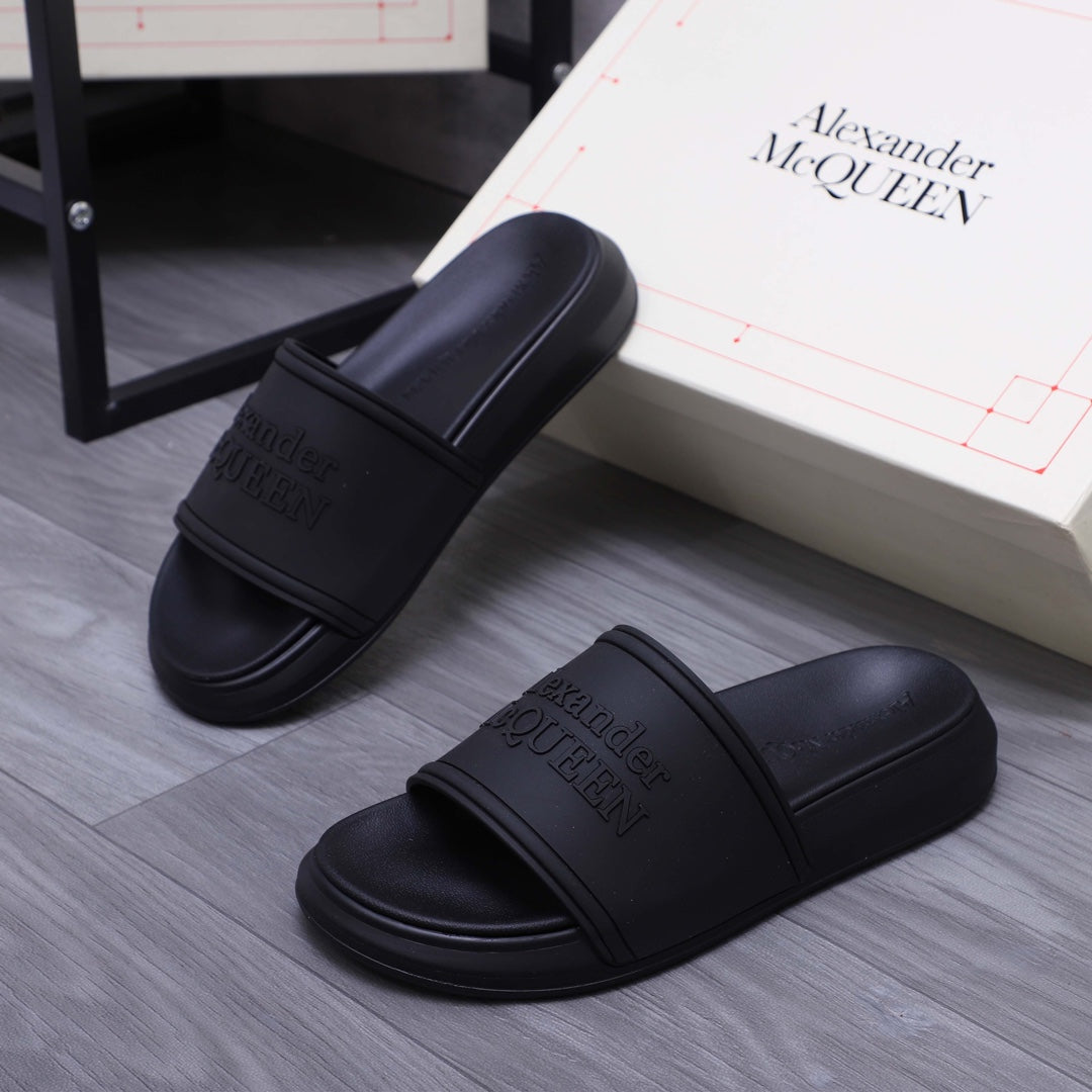 Alexander McQueen black slide sandals, logo-embossed strap, angled top views