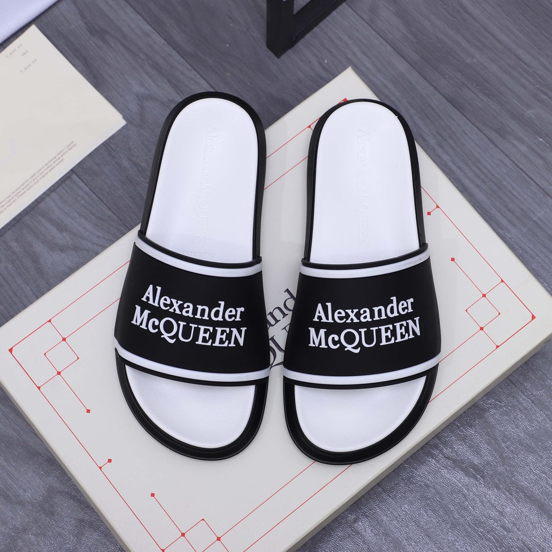 Black and white slide sandals with Alexander McQueen logo on the strap