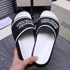 Black slide sandals with Alexander McQueen logo print on inner footbed