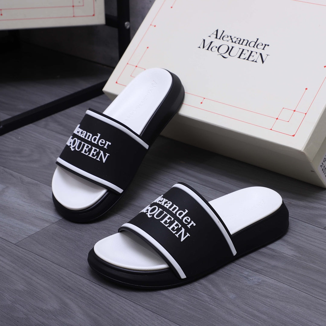 Pair of black slide sandals with white footbeds and Alexander McQueen logo