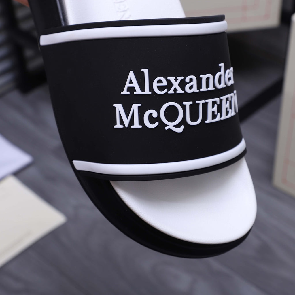 Close-up: black slide strap with Alexander McQueen logo and white trim