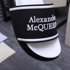 Close-up: black slide strap with Alexander McQueen logo and white trim