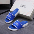 Blue slide sandals with white soles and Alexander McQUEEN logo straps