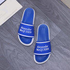 Pair of blue slide sandals with white trim and Alexander McQUEEN branding