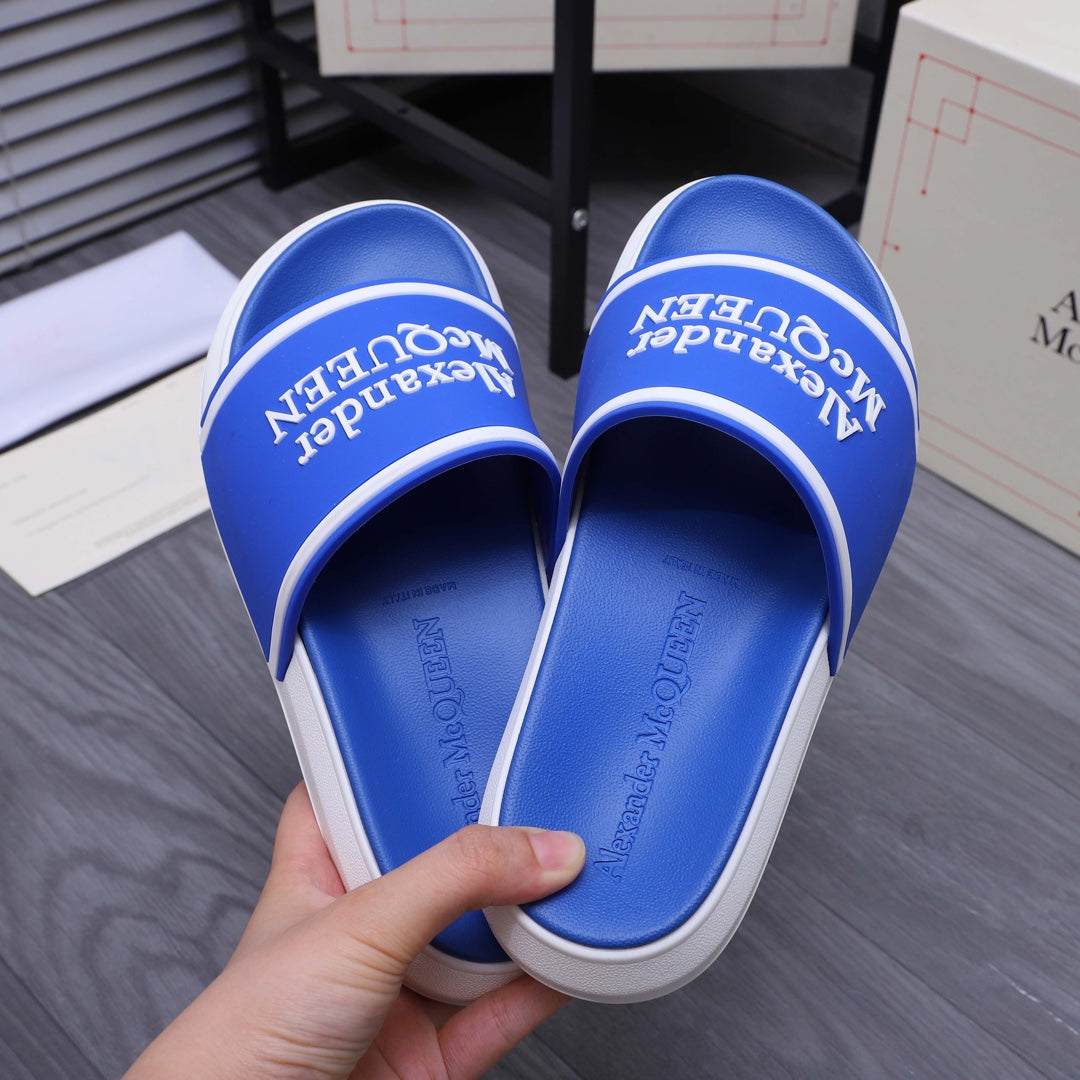 Blue slide sandals with white trim; Alexander McQUEEN text on footbed