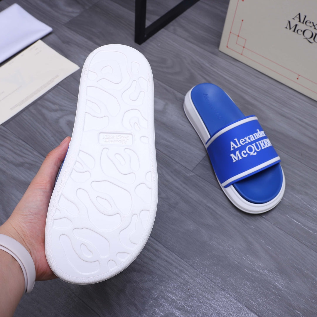 Blue slide sandal outsole view with white textured sole and Alexander McQUEEN strap