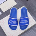 Blue slide sandals with white trim and Alexander McQUEEN logo on straps