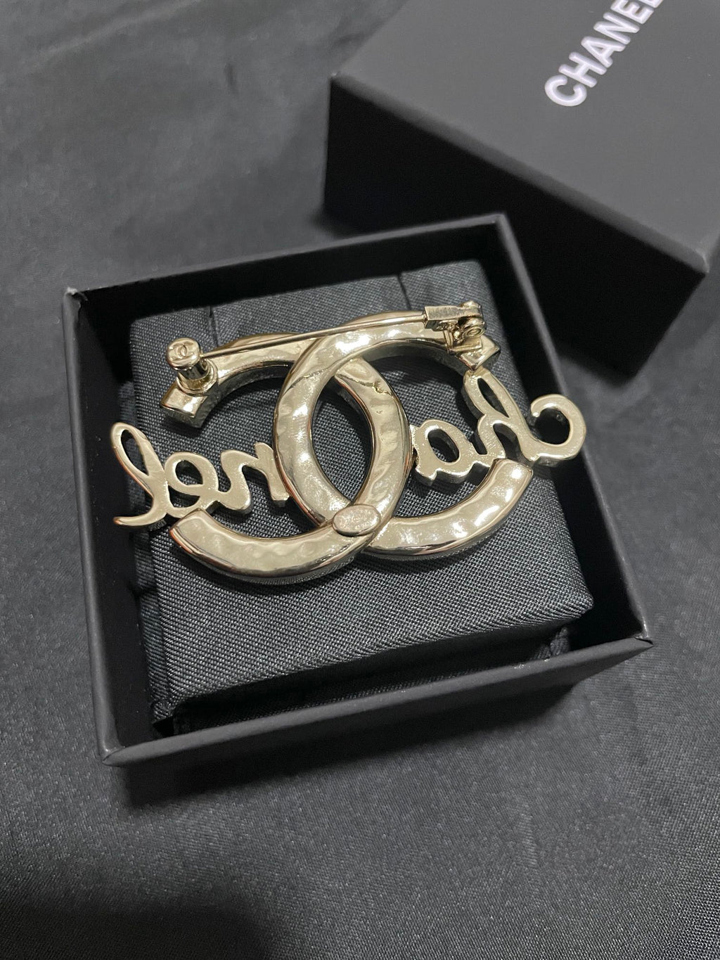 Gold-tone Chanel brooch with oval O script motif, polished metal finish