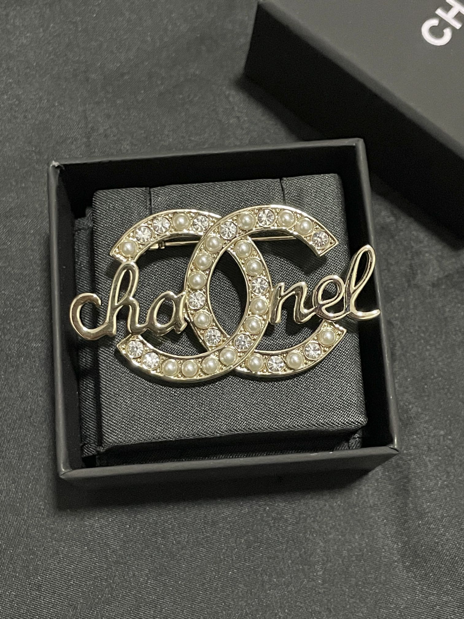Gold-tone Chanel brooch with pearl and crystal accents, script logo detail