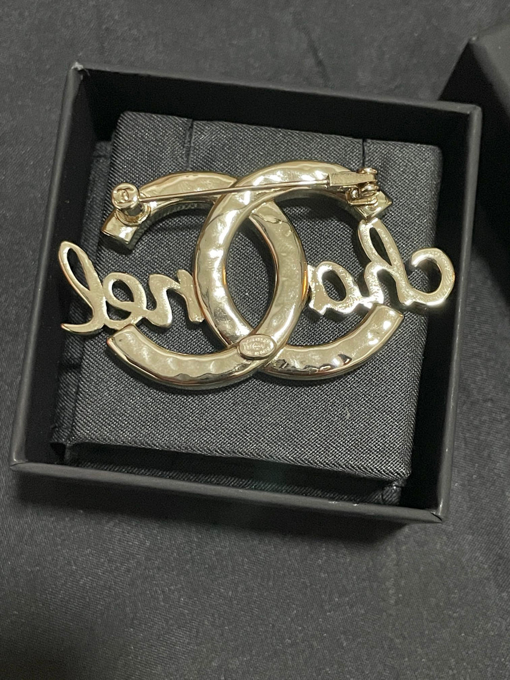 Gold-tone Chanel brooch with polished metal finish, oval O script motif