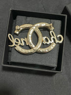 Gold-tone Chanel brooch with polished metal finish, oval O script motif
