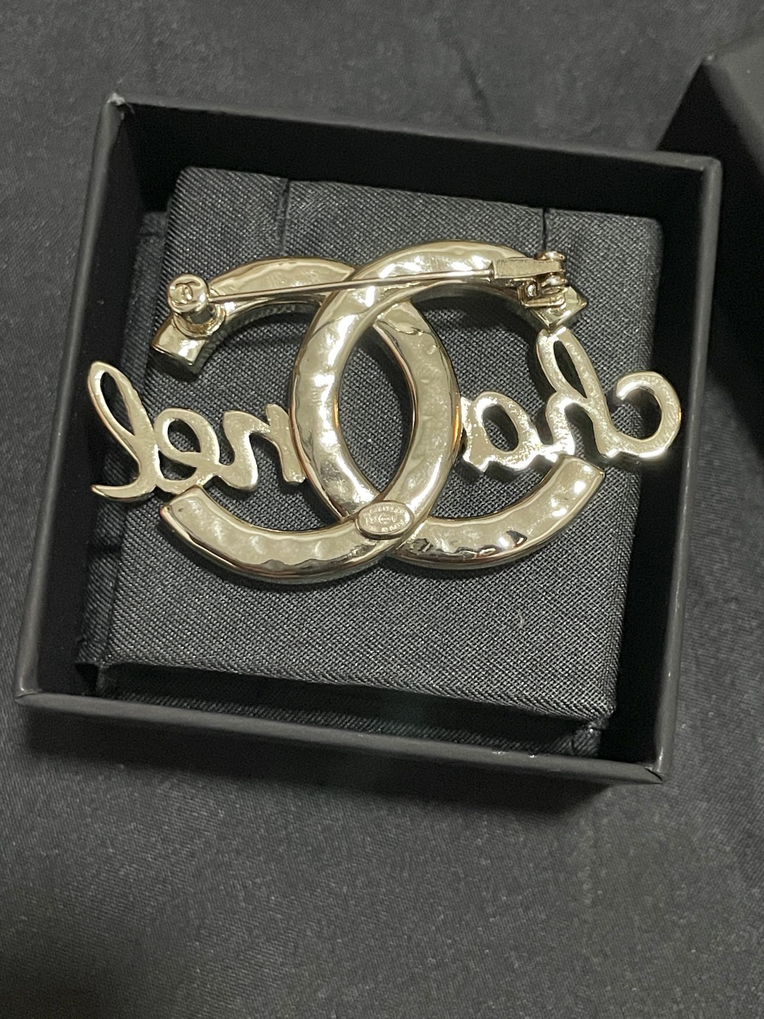 Gold-tone Chanel brooch with polished metal finish, oval O script motif