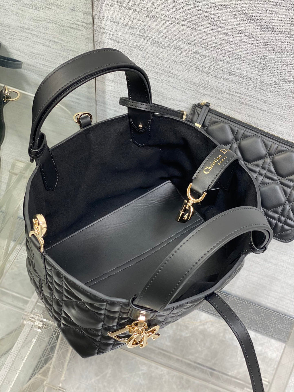 Black Dior bucket-style handbag with side handles and detachable strap