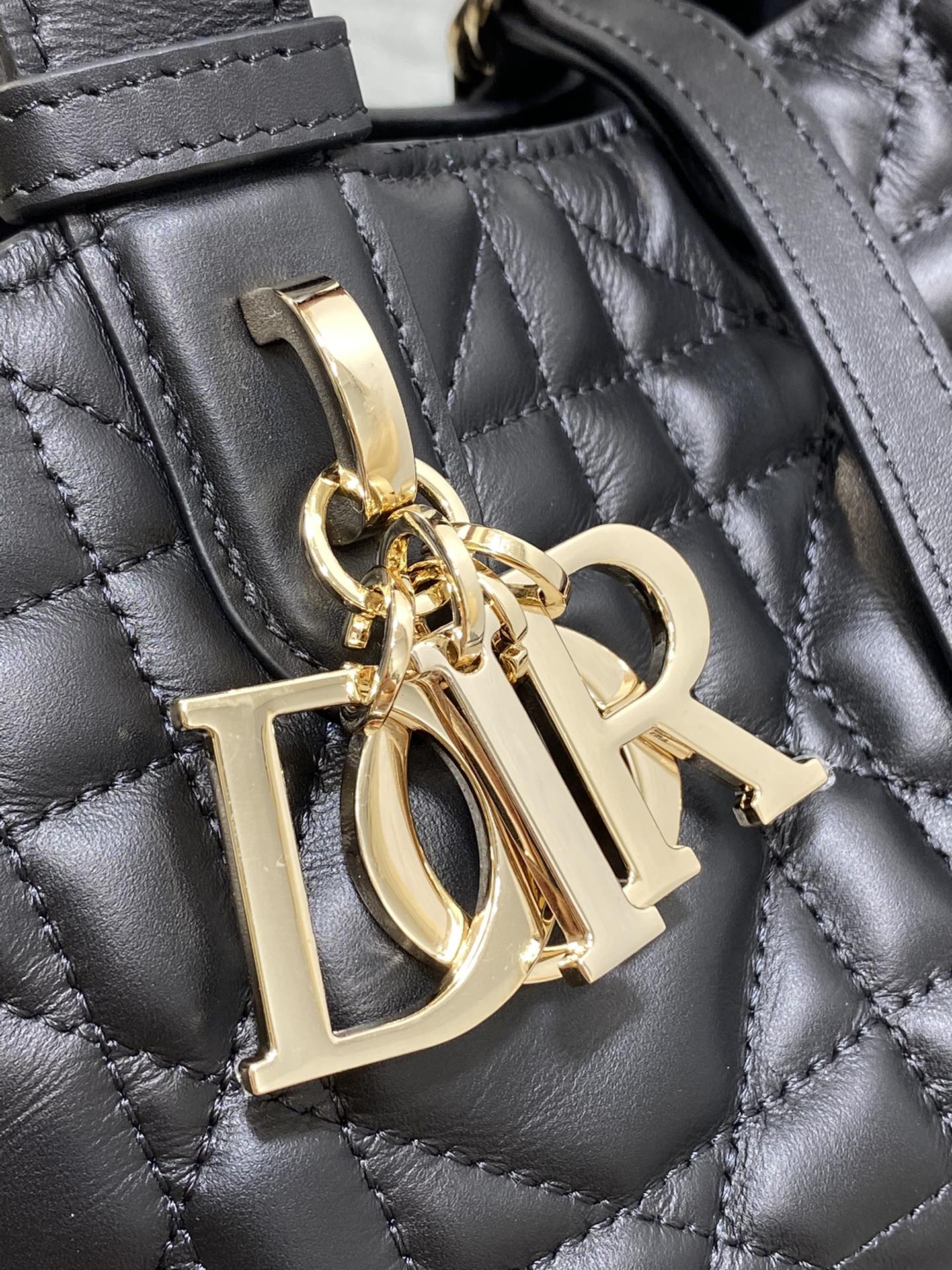 Black quilted handbag clasp with gold-tone 'Dior' charm detail