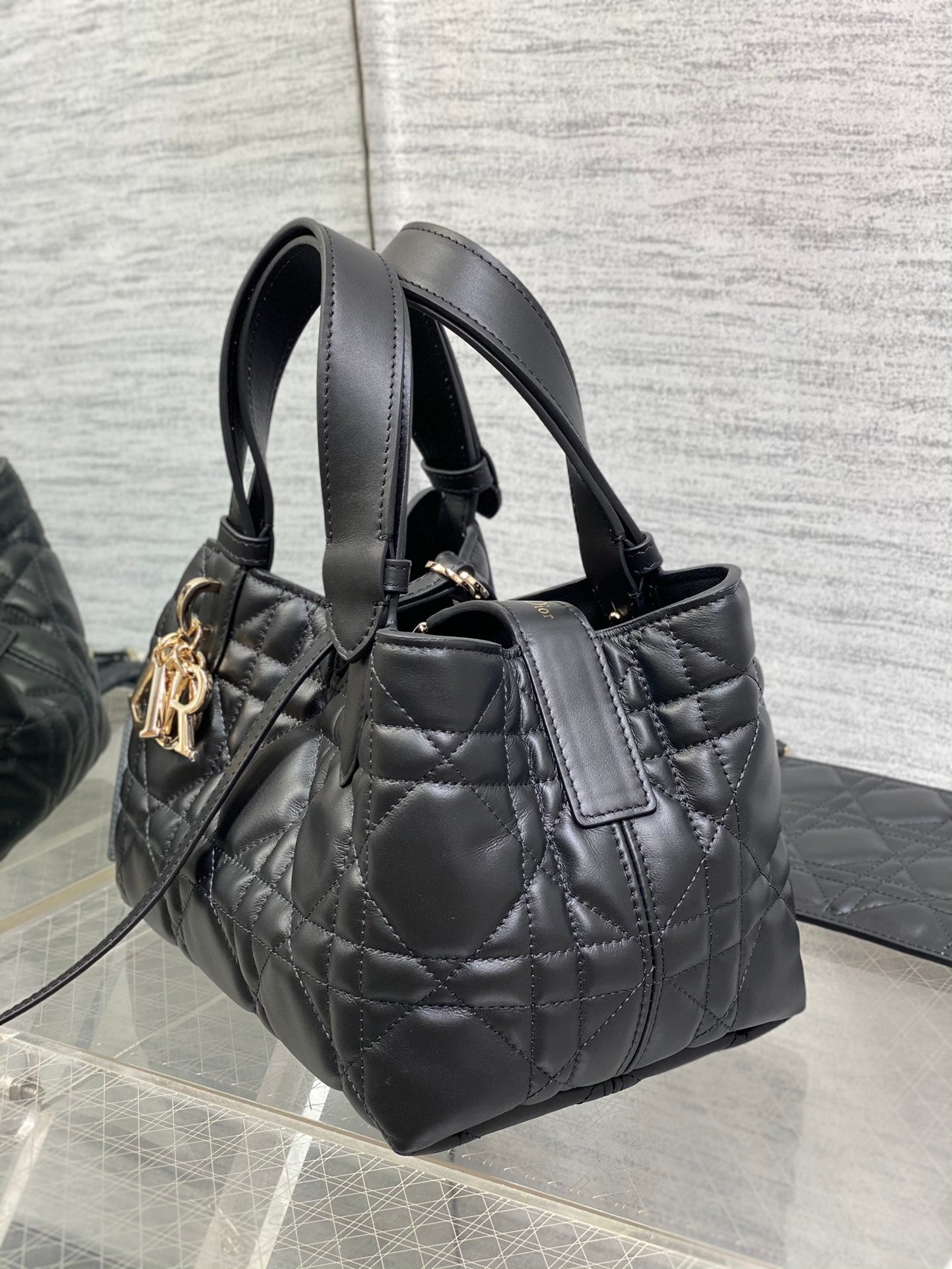 Black quilted Dior shoulder bag with top handles and adjustable strap