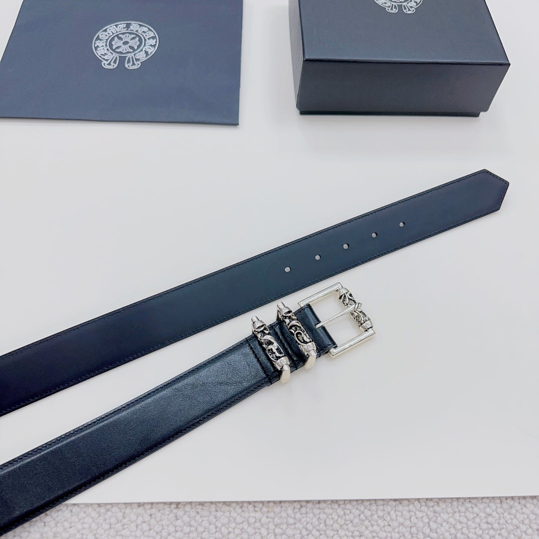 Dark leather belt strap with silver buckle hardware and etched accents, close-up