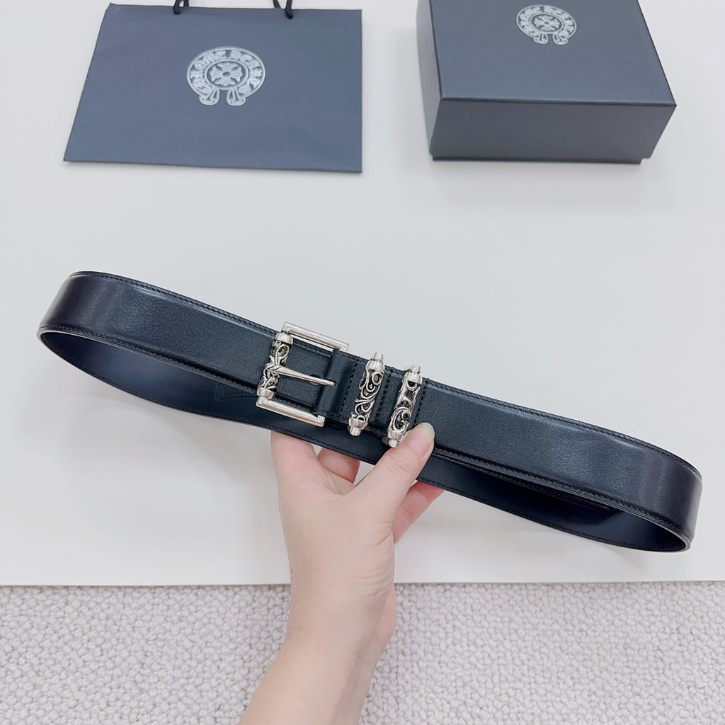 Dark leather belt with silver buckle and decorative metal accents, strap laid out
