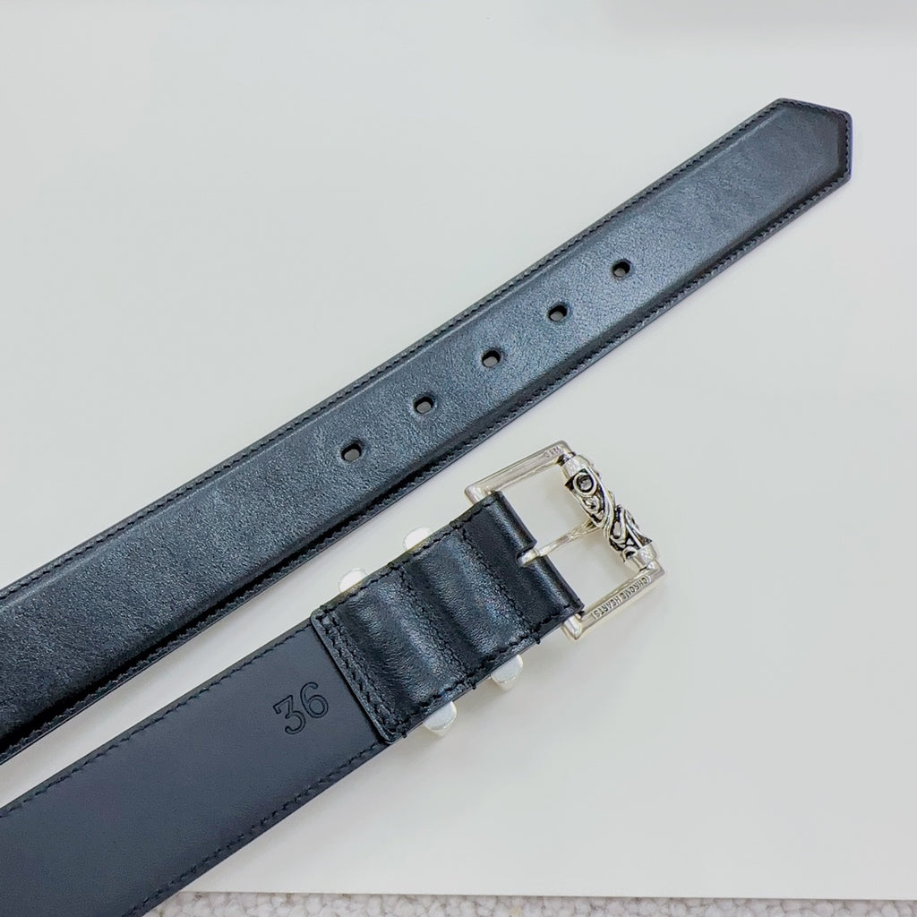 Dark leather belt with perforation holes and silver buckle clasp, close-up