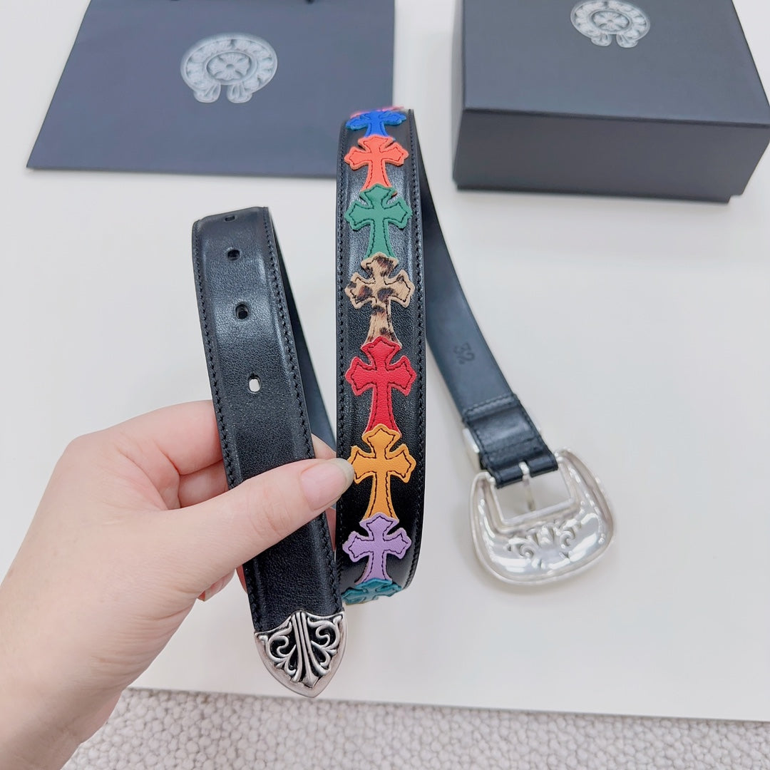 Dark blue belt with silver buckle and colorful cross embroidery panel, held in hand.